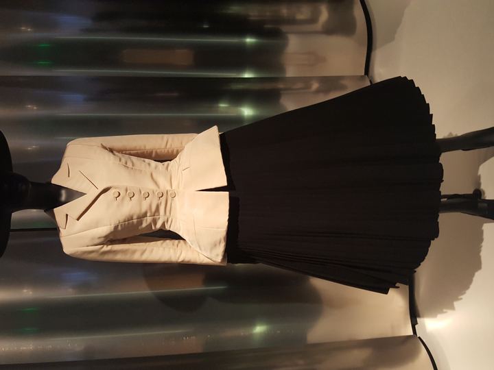 Christian Dior's Bar suit from spring 1947, with a cream fitted jacket and full black pleated skirt, at the Denver Art Museum