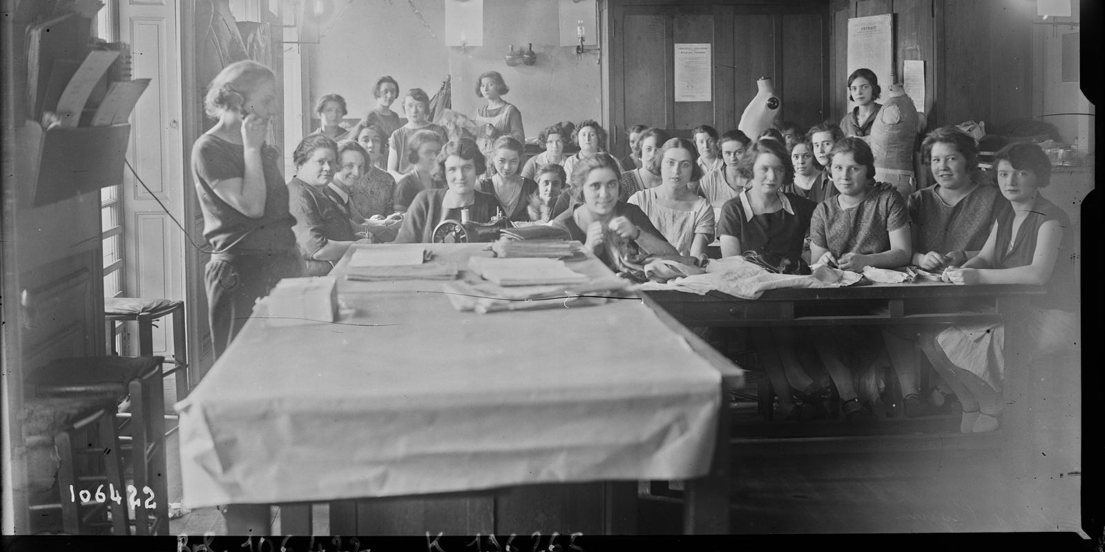 A black and white photograph from 1926 of seamstresses seated around a long worktable in the Paquin atelier