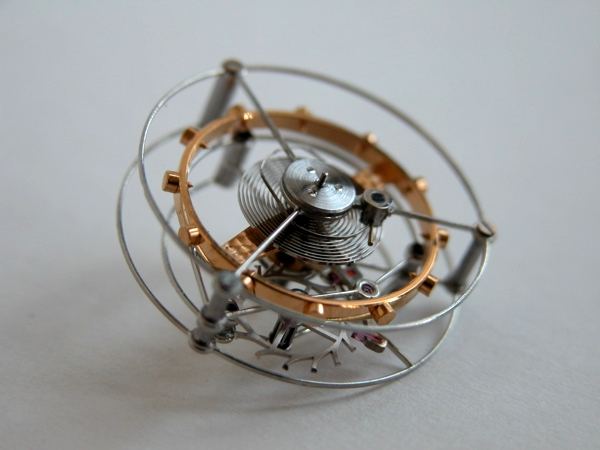 A macro photograph of a tourbillon cage on its own, showing the balance spring