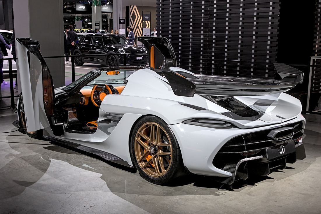 A white Koenigsegg Jesko with its doors raised at a motor show