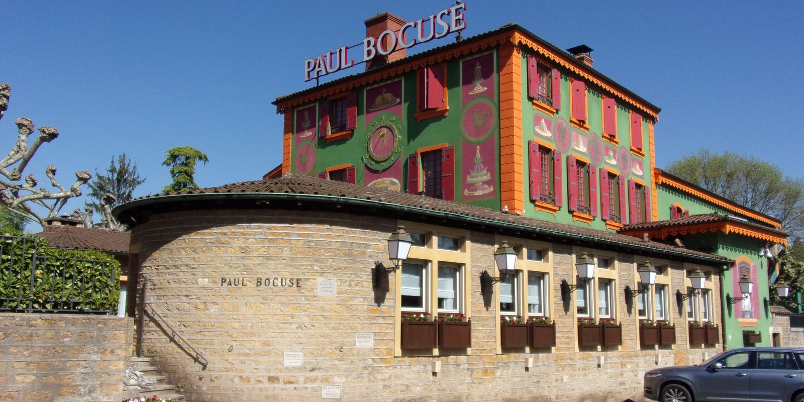 The brightly painted red and green facade of L'Auberge du Pont de Collonges, the restaurant of Paul Bocuse